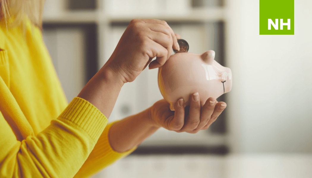 Woman holding a coin over piggy bank